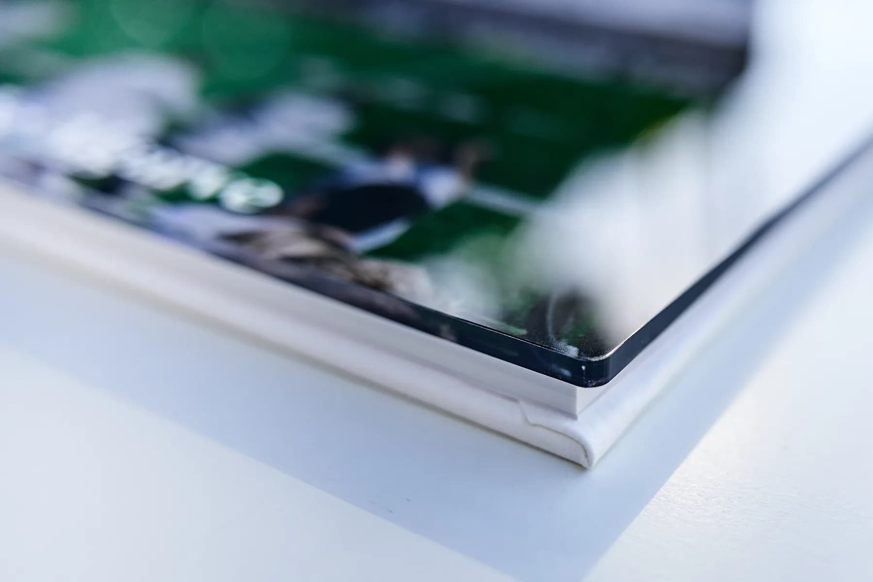 The corner of the acrylic cover plate of a MakeAlbum book